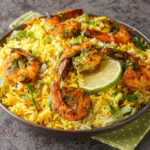 Popular Iranian seafood pilaf Meygoo Polo with herbs and prawns closeup on the plate on the table