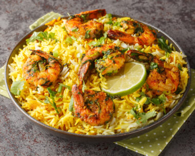 Popular Iranian seafood pilaf Meygoo Polo with herbs and prawns closeup on the plate on the table