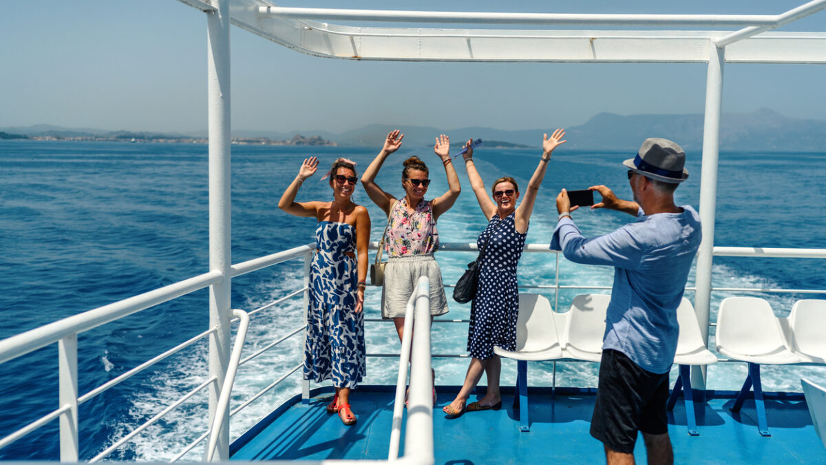 Group of friends on the ferry boat deck on a sunny day traveling on vacation