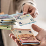 Businesswoman's hands exchanging euro banknotes, closeup shot