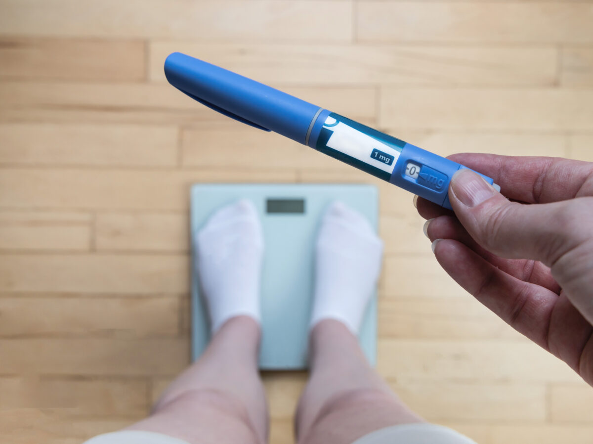 Ozempic Insulin injection pen for diabetics and weight loss. Woman weighs herself and holds Ozempic in her hand. Weight loss concept.