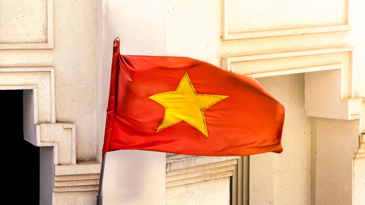 A red national flag of Vietnam stands as a significant symbol of the country, fluttering above the streets and embodying the spirit of the nation.