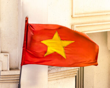 A red national flag of Vietnam stands as a significant symbol of the country, fluttering above the streets and embodying the spirit of the nation.