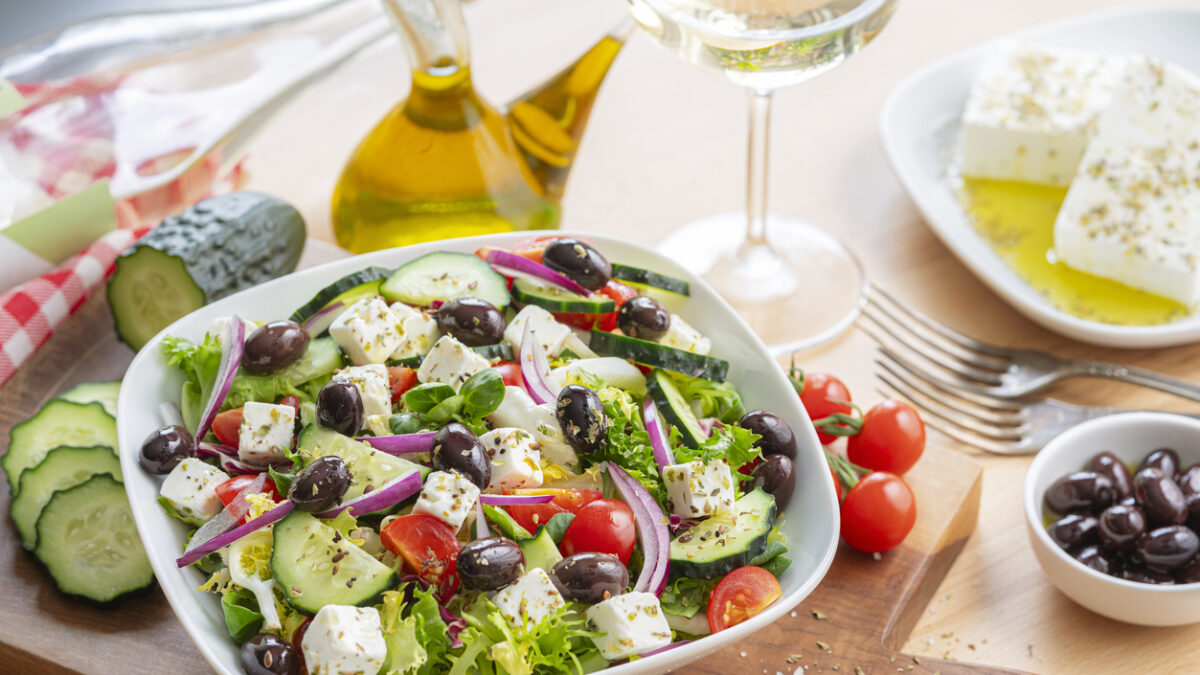 Healthy and fresh Greek salad plate bowl on dining table. Feta cheese, black olives, tomatoes and cucumber