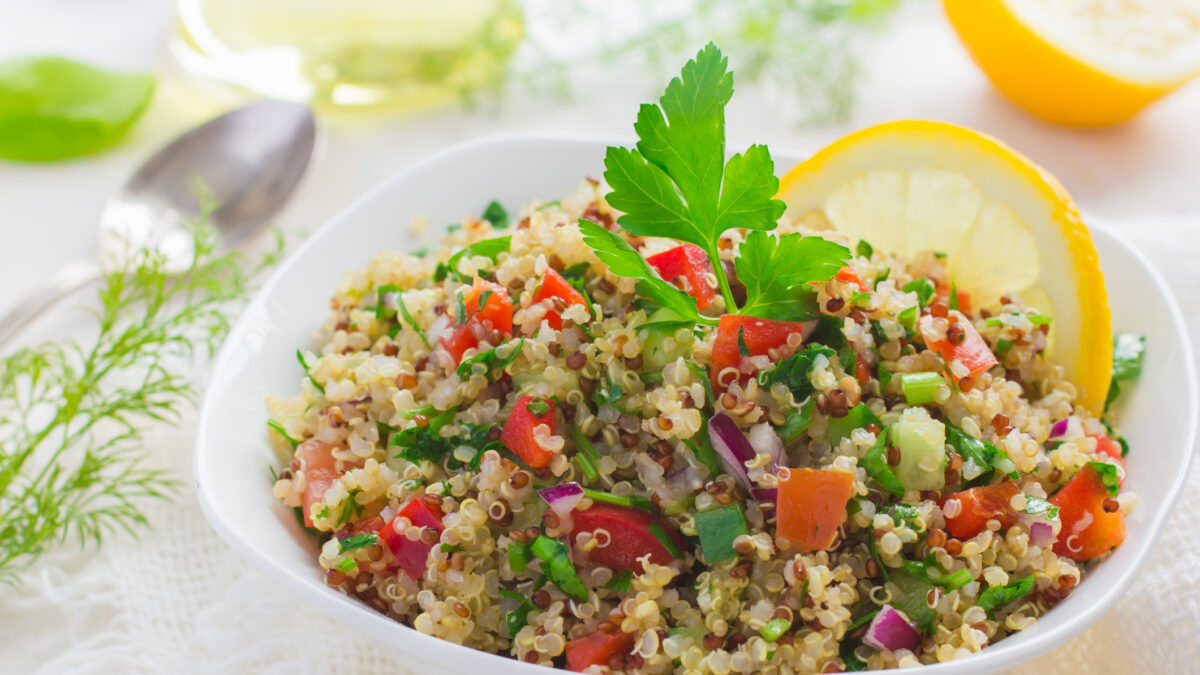 Tabbouleh salad with quinoa, parsley and vegetables on white background
