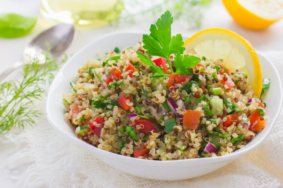 Tabbouleh salad with quinoa, parsley and vegetables on white background