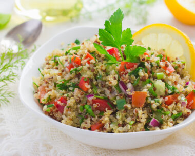Tabbouleh salad with quinoa, parsley and vegetables on white background