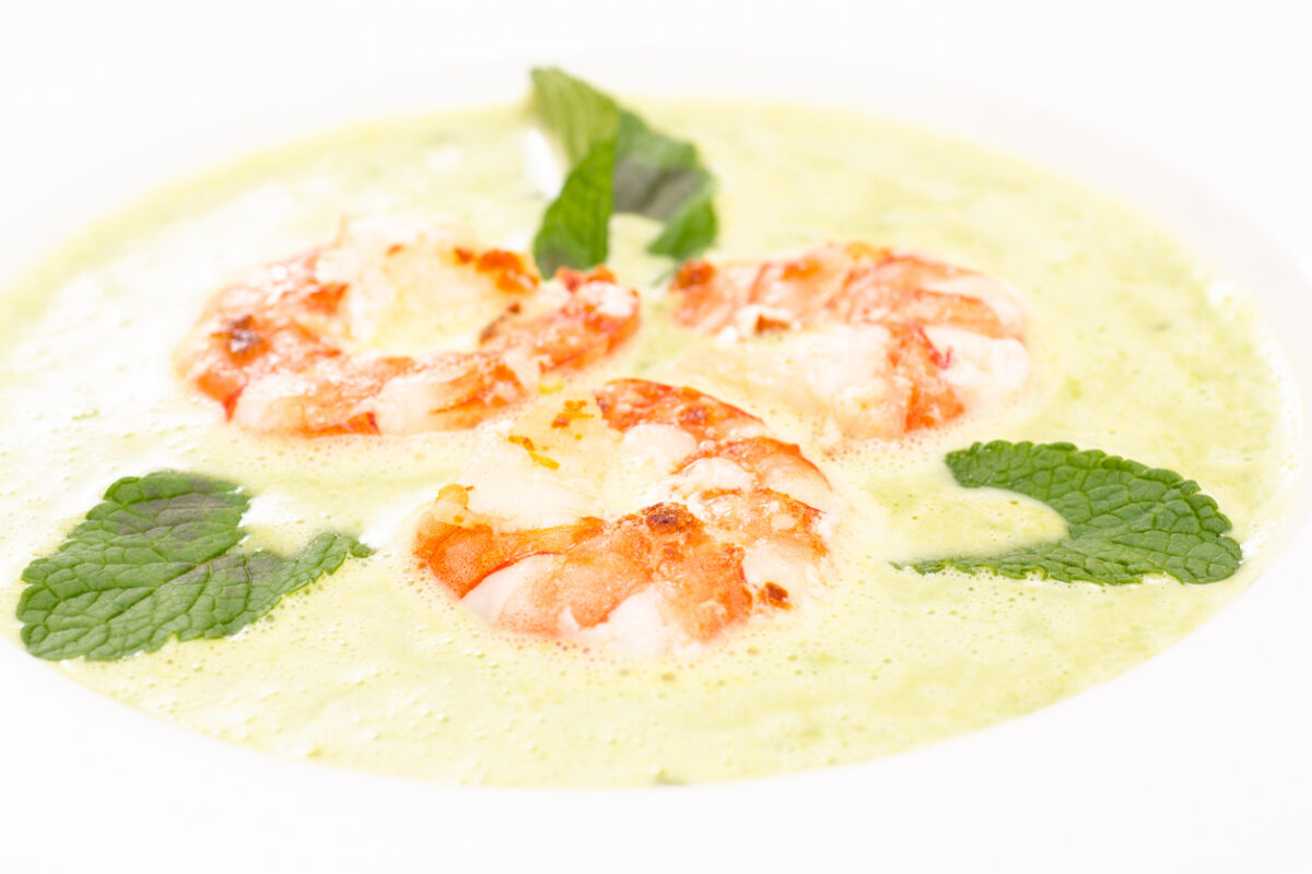 Close up of shrimps with green soup of mint