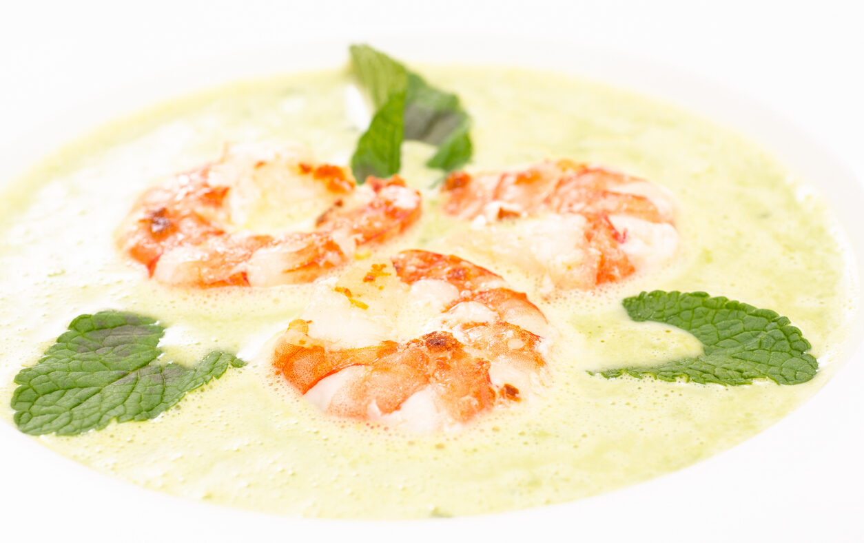 Close up of shrimps with green soup of mint