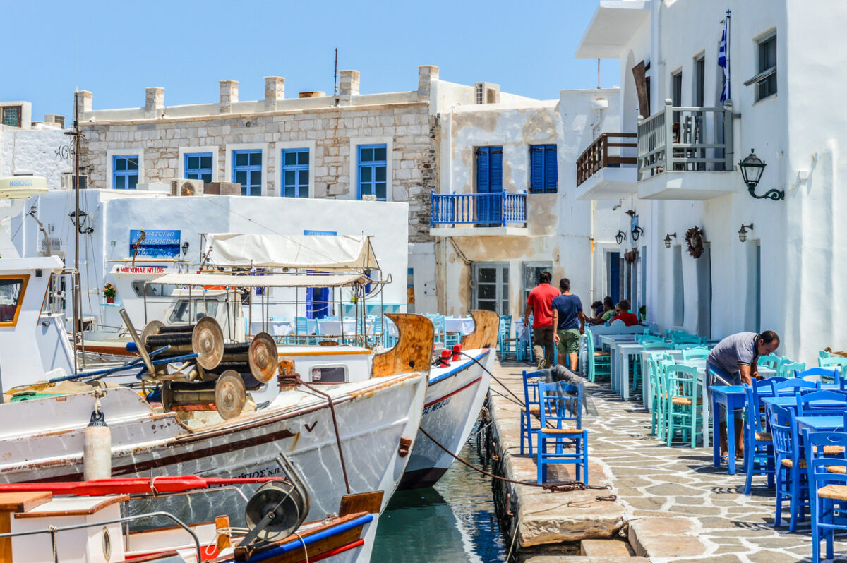Paros, Greece - June 17, 2016: Beautiful harbor of Naoussa on Paros Island. Picture was taken in the harbor where there is always activity from the may fishing boats and visitors that come to enjoy the scenary and get a bit to eat. At night the harbor is a thriving nightlife district.