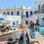 Paros, Greece - June 17, 2016: Beautiful harbor of Naoussa on Paros Island. Picture was taken in the harbor where there is always activity from the may fishing boats and visitors that come to enjoy the scenary and get a bit to eat. At night the harbor is a thriving nightlife district.