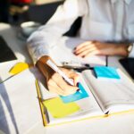 Cropped image of creative female secretary creating planning for executive noting important meeting and events organizing work of busy boss while sitting at working place in coworking office