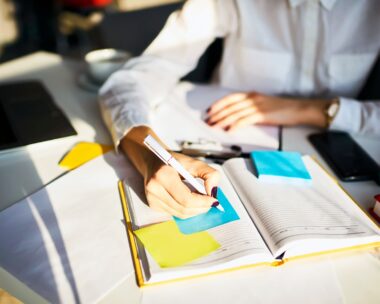 Cropped image of creative female secretary creating planning for executive noting important meeting and events organizing work of busy boss while sitting at working place in coworking office