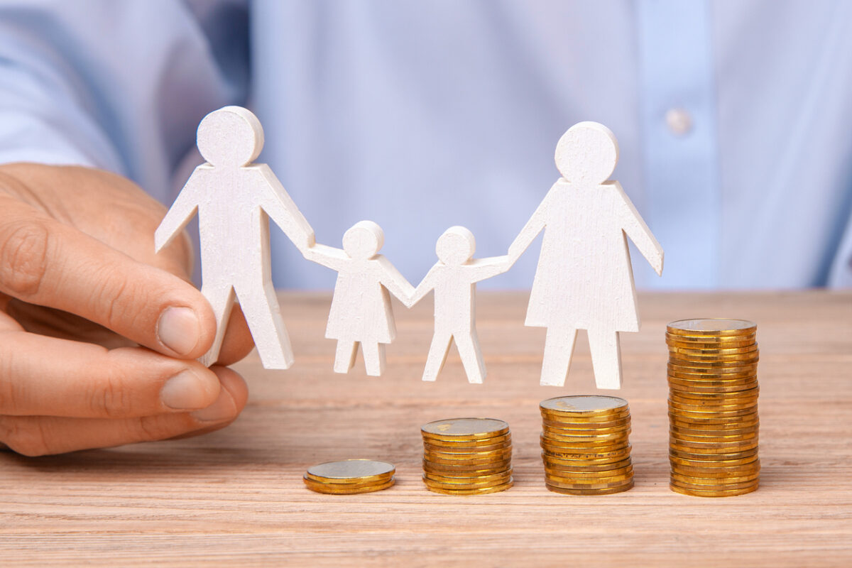 Budget of the family. Coins pile and the symbol of the family with the pope, mother, daughter and son