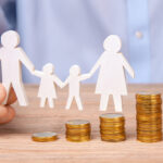 Budget of the family. Coins pile and the symbol of the family with the pope, mother, daughter and son