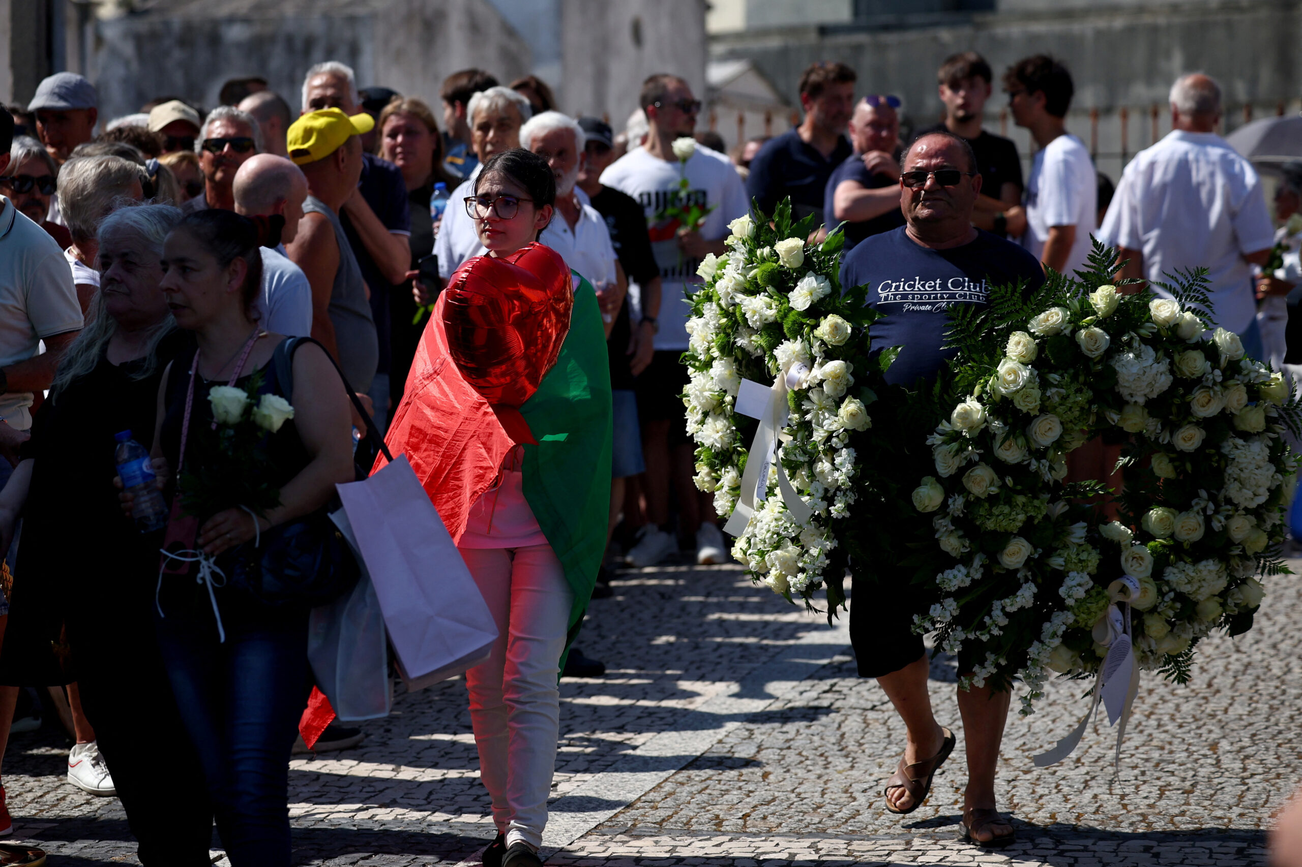 A man carries flowers as people wait to pay their respect during the wake for Liverpool's Portuguese soccer player Diogo Jota and his brother Andre Silva, who died in a car crash near Zamora, Spain, near the Chapel of the Resurrection, in Gondomar, Portugal, July 4, 2025. REUTERS