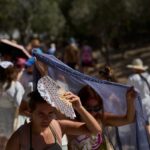 Τουρίστες προσπαθούν να προστατευτούν από τη ζέστη στην Αθήνα