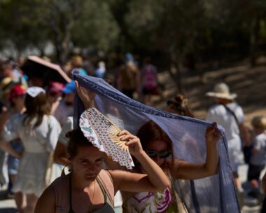 Τουρίστες προσπαθούν να προστατευτούν από τη ζέστη στην Αθήνα