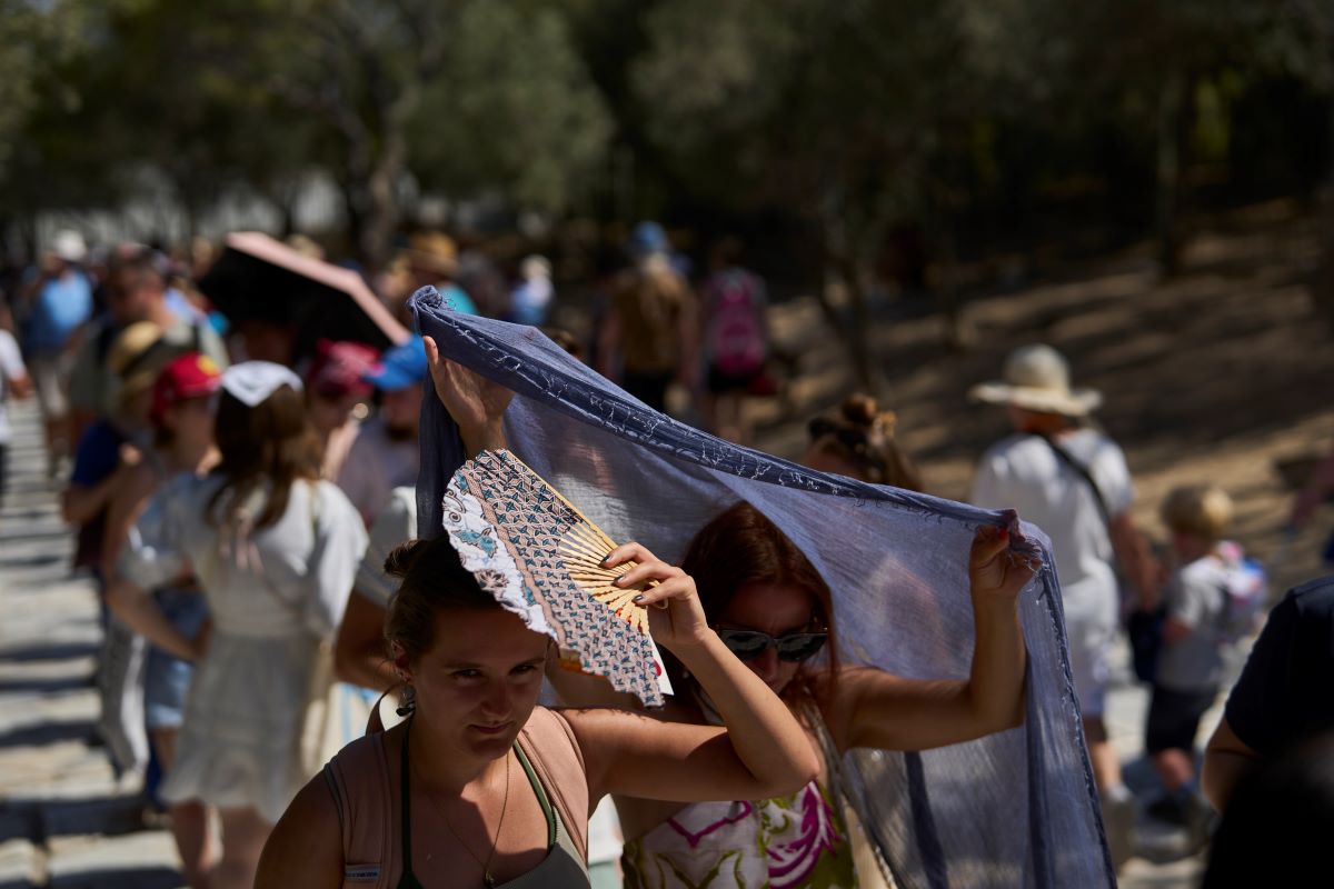 Τουρίστες προσπαθούν να προστατευτούν από τη ζέστη στην Αθήνα