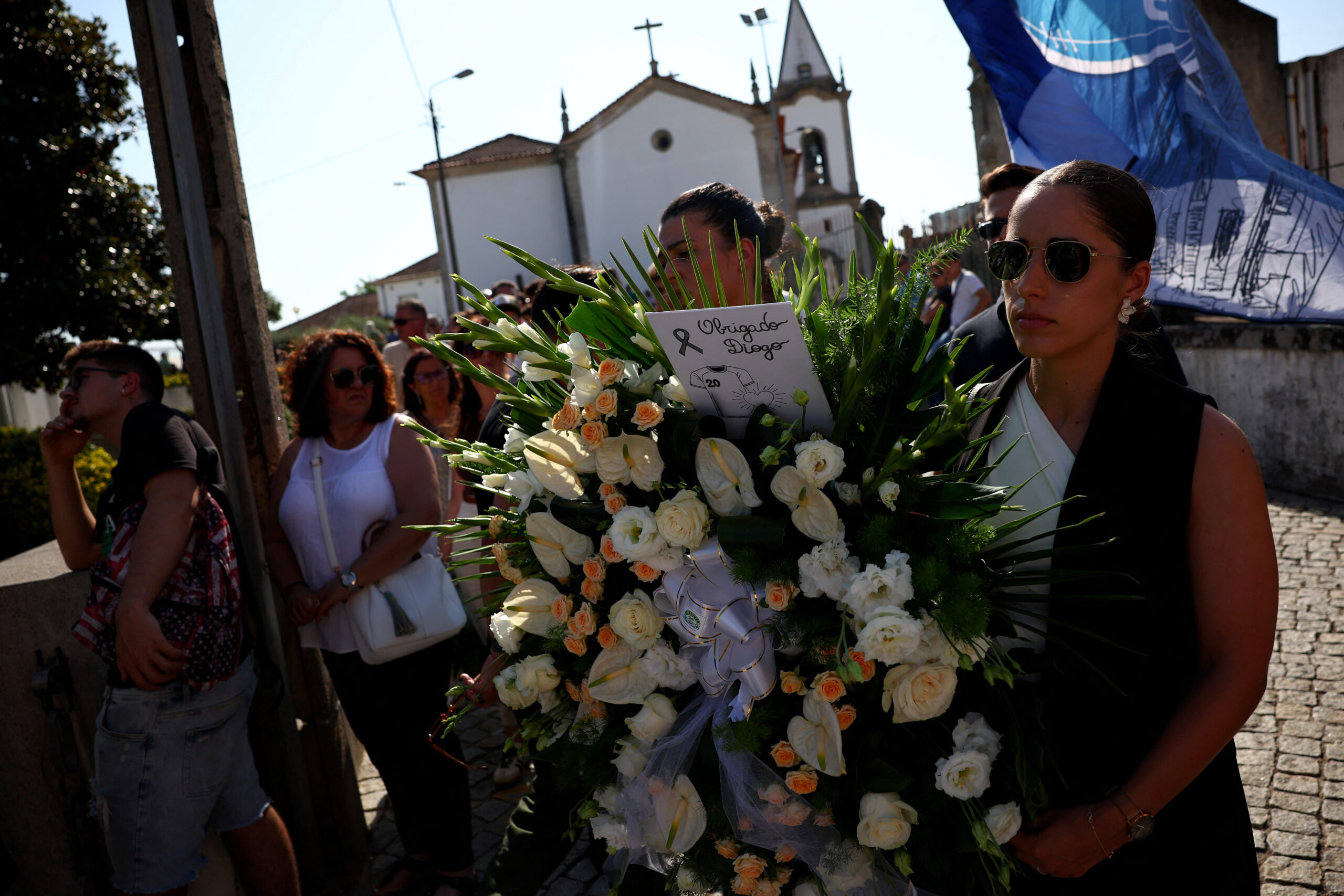 People carry flowers as they wait to pay their respect during the wake for Liverpool's Portuguese soccer player Diogo Jota and his brother Andre Silva, who died in a car crash near Zamora, Spain, near the Chapel of the Resurrection, in Gondomar, Portugal, July 4, 2025. REUTERS