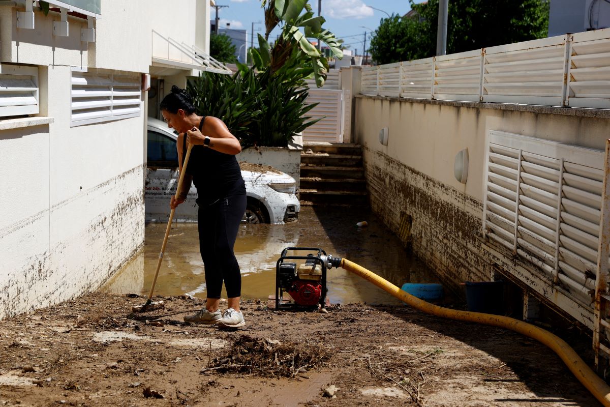 Resident cleans the entrance of her garage after the Fua River overflow