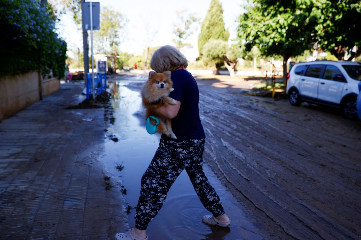 A woman walks on a flooded road in Barcelona