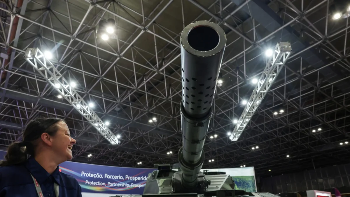 A person reacts next to a tank during LAAD, the biggest military industry expo in Latin America