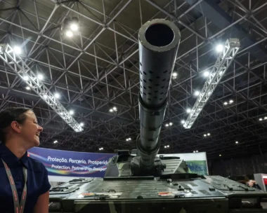 A person reacts next to a tank during LAAD, the biggest military industry expo in Latin America