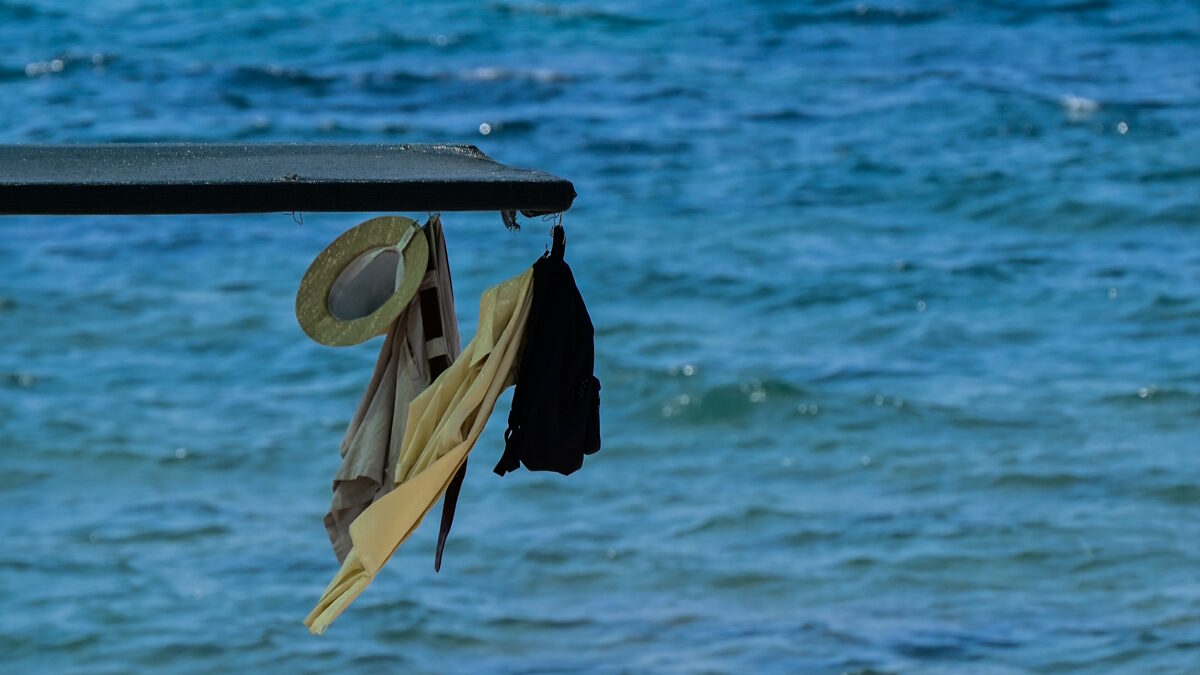 Ρούχα κρέμονται από ομπρέλα στην θάλασσα