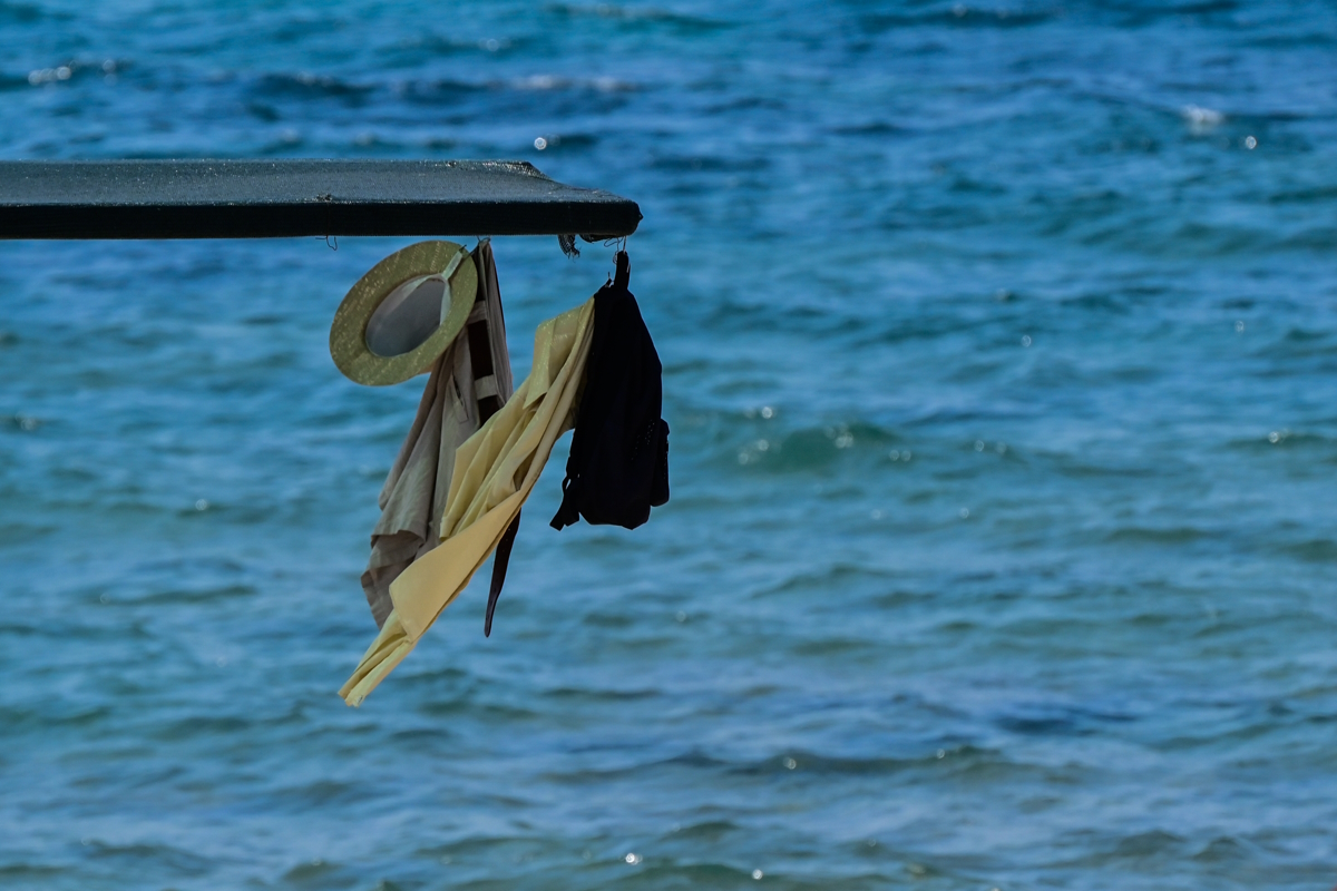 Ρούχα κρέμονται από ομπρέλα στην θάλασσα