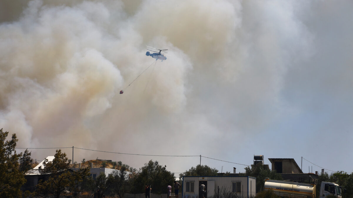 Ένα πυροσβεστικό ελικόπτερο πετάει πάνω από τον καπνό που αναδύεται από την πυρκαγιά στην Αττάλεια / REUTERS / Kaan Soyturk