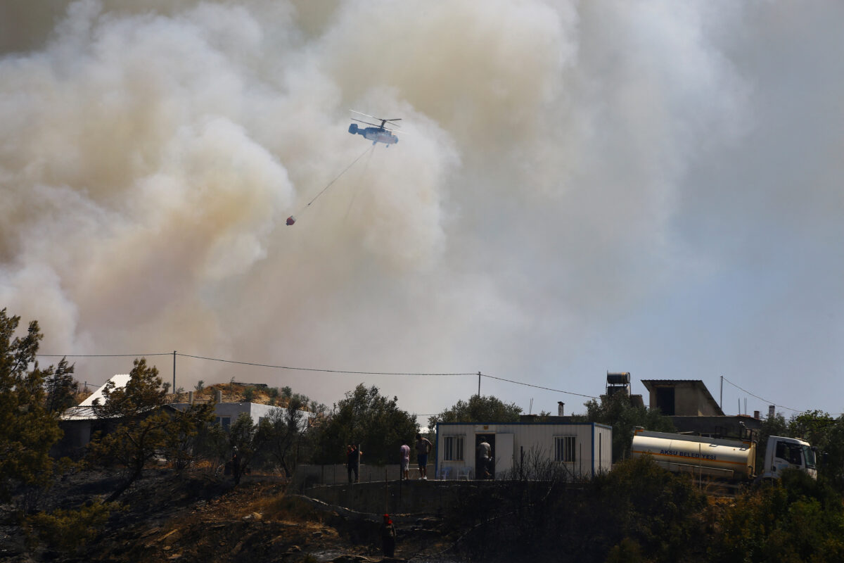 Ένα πυροσβεστικό ελικόπτερο πετάει πάνω από τον καπνό που αναδύεται από την πυρκαγιά στην Αττάλεια / REUTERS / Kaan Soyturk