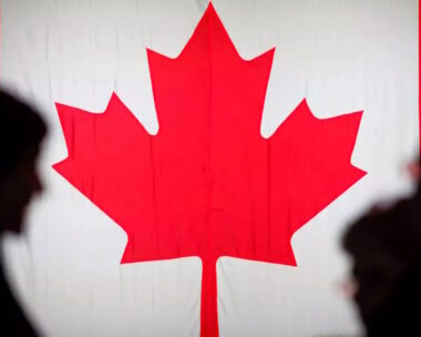 People are silhouetted in front of the Canadian national flag at the Palais des Congres in Montreal, Quebec, Canada October 21, 2019.