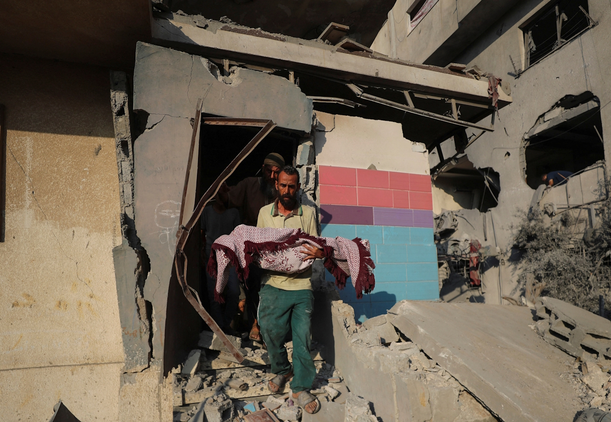 Palestinian carries the body of a child killed during Israeli air raid on Gaza