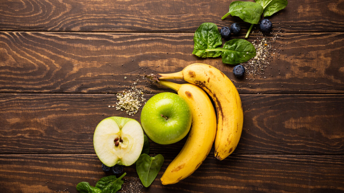 Ingredients fot healthy breakfast detox green smoothie bowl from banana, apples and spinach on wooden background. View from above.