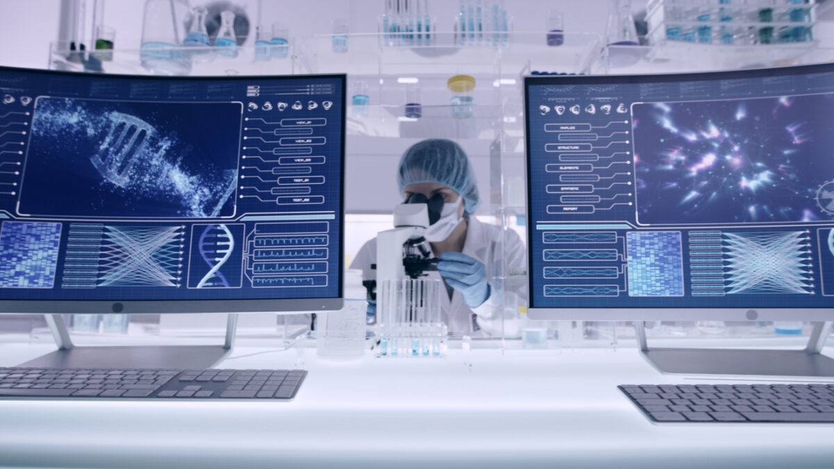 Scientist examines DNA models in modern Genetic Research Laboratory. Looking through laboratory glassware
