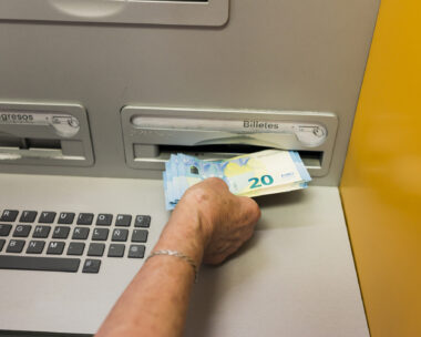 Arahal, Seville, Spain. May 25, 2022. Detail of an elderly woman's hand withdrawing cash from an ATM. Some elderly people have difficulty using ATMs.
