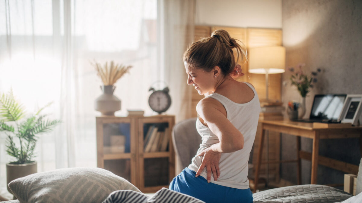woman in bed having backache
