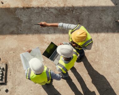 Top view, Team engineer building inspection use tablet computer and blueprint working at construction site. Civil Engineer, Contractor and Architect discussing in construction site.