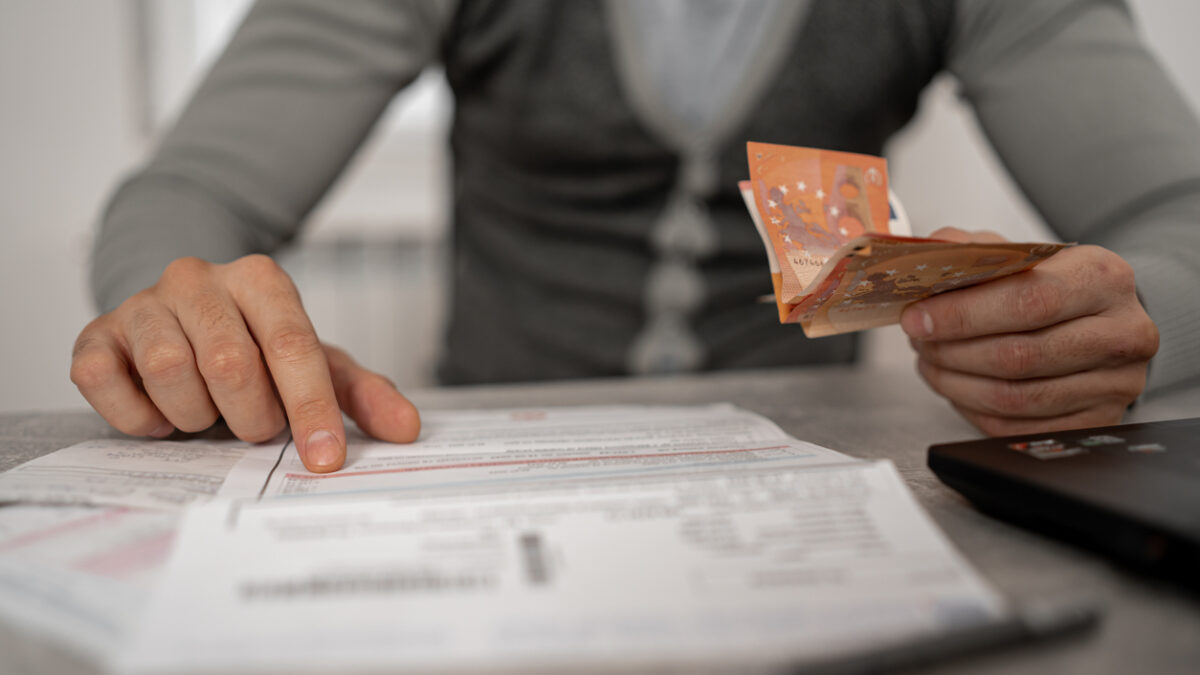 With a furrowed brow and a deep sense of anxiety, the mid-adult man works to manage his bills and debt