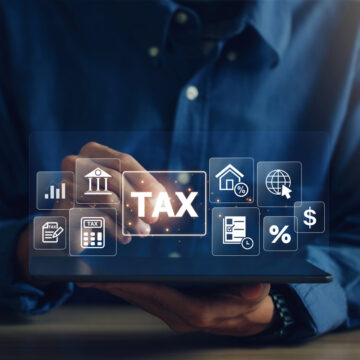 E-tax, A Businessman using a tablet to fill in the income tax online return form for payment.Calculation of tax return.Government, state taxes. Data analysis, paperwork, financial research, reports.