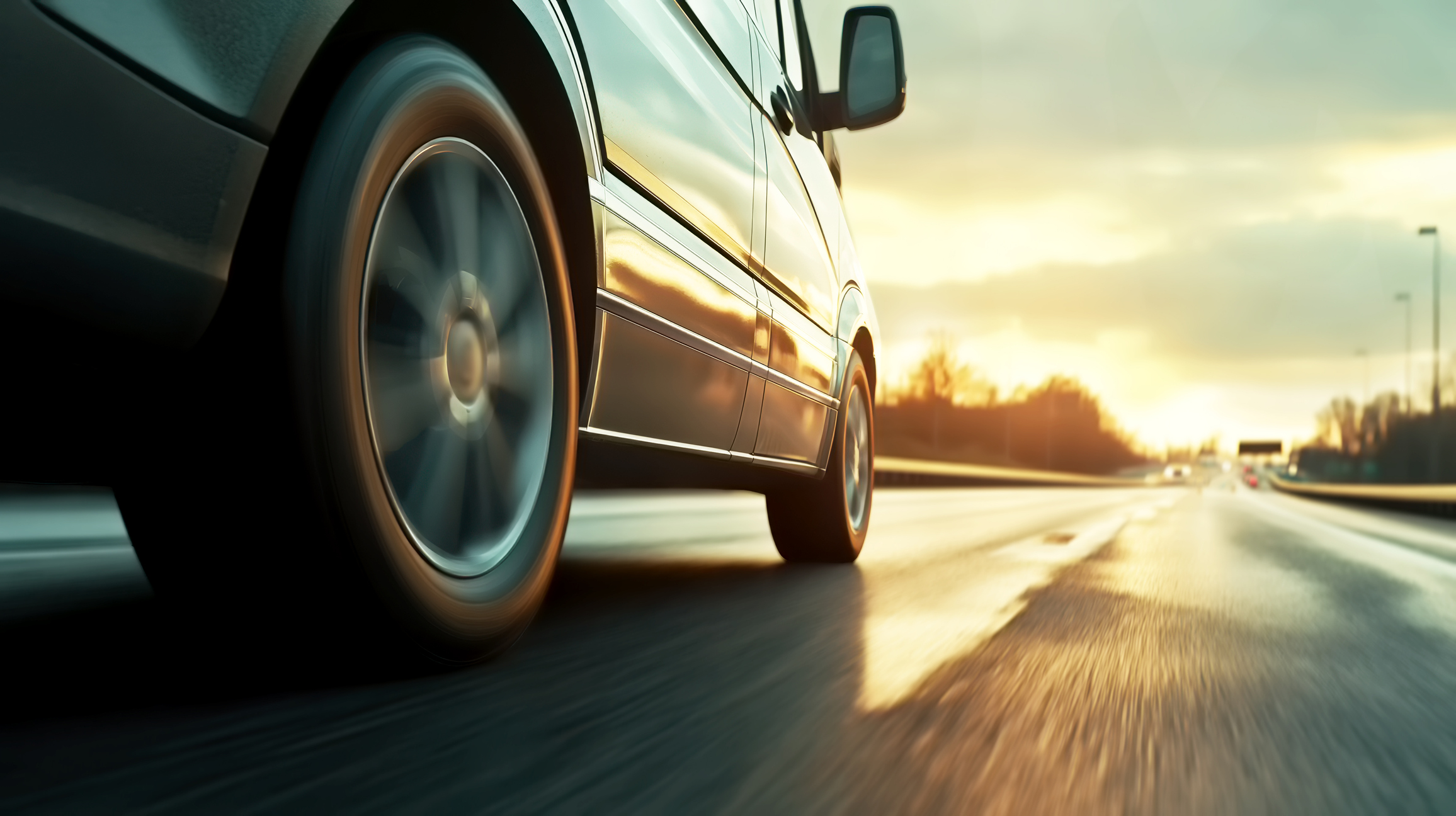 Car rushes along the highway at sunset , low angle side view Φωτογραφία: iStock