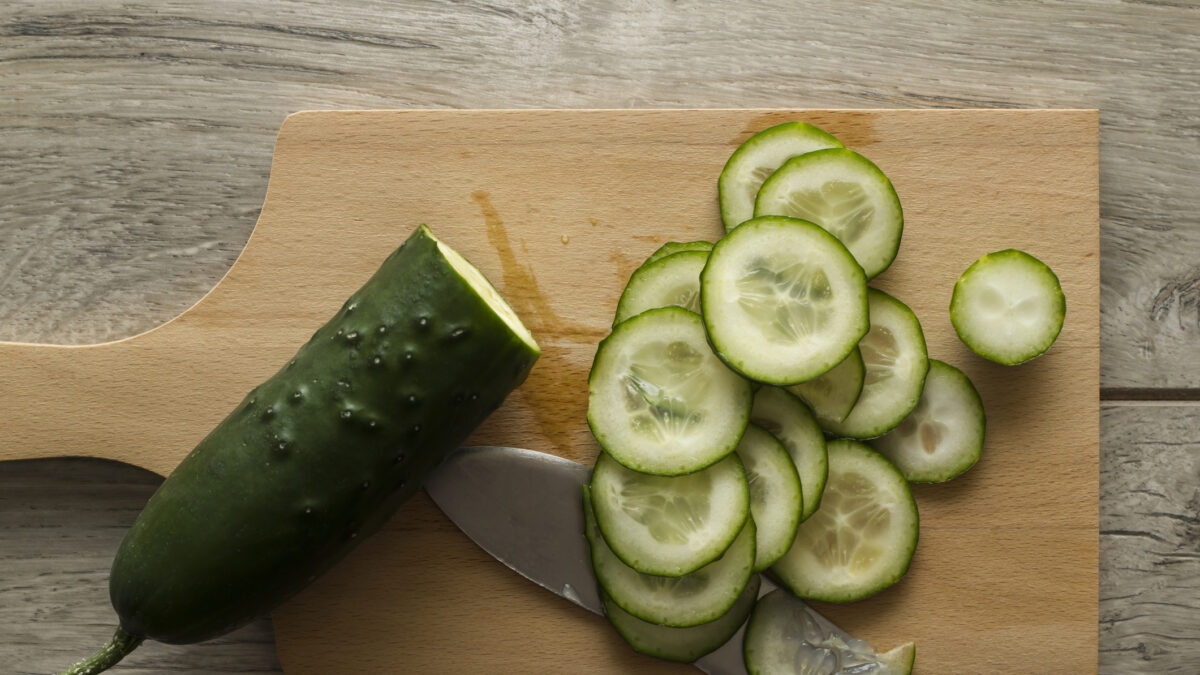 Sliced cucumber on wooden kitchen board. Directly above view. Photo is taken with dslr camera in studio.