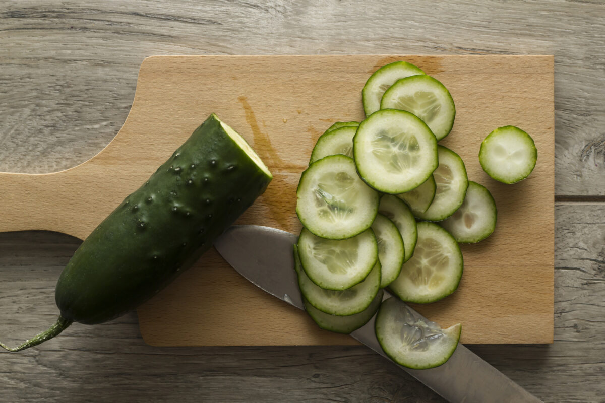 Sliced cucumber on wooden kitchen board. Directly above view. Photo is taken with dslr camera in studio.