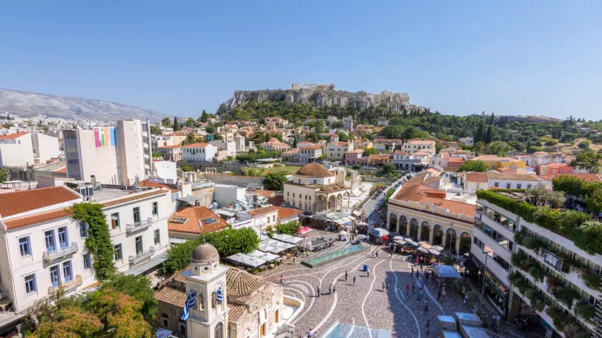 Athens, Greece - June 14, 2017. People visiting Monastiraki square as seen from a high point of view. Akropolis and Plaka in the background