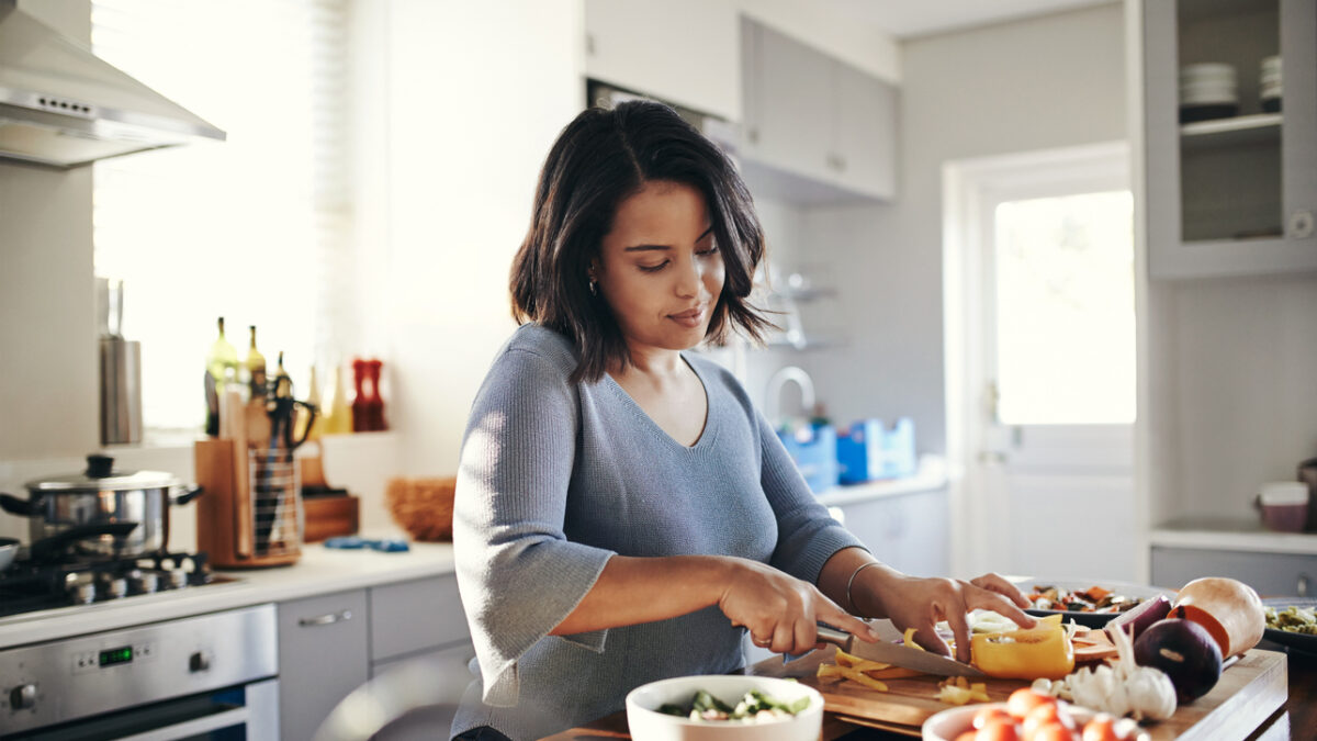 Shot of an attractive young woman cooking at home