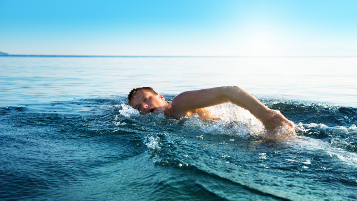 young man swiming in oceans water