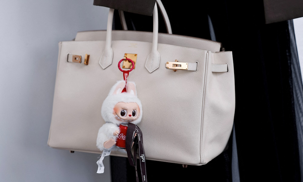 FILE PHOTO: A Labubu toy hangs from a bidder's Hermes bag at an auction by Yongle International Auction in Beijing, China June 10, 2025. REUTERS