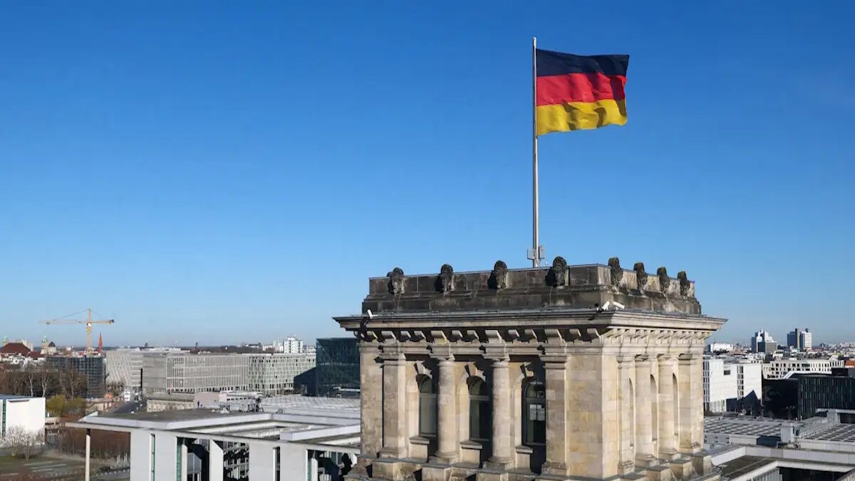 German national flag flutters on top of the Reichstag building