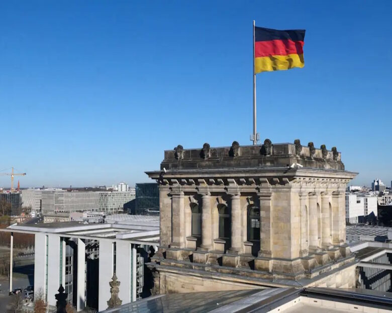German national flag flutters on top of the Reichstag building